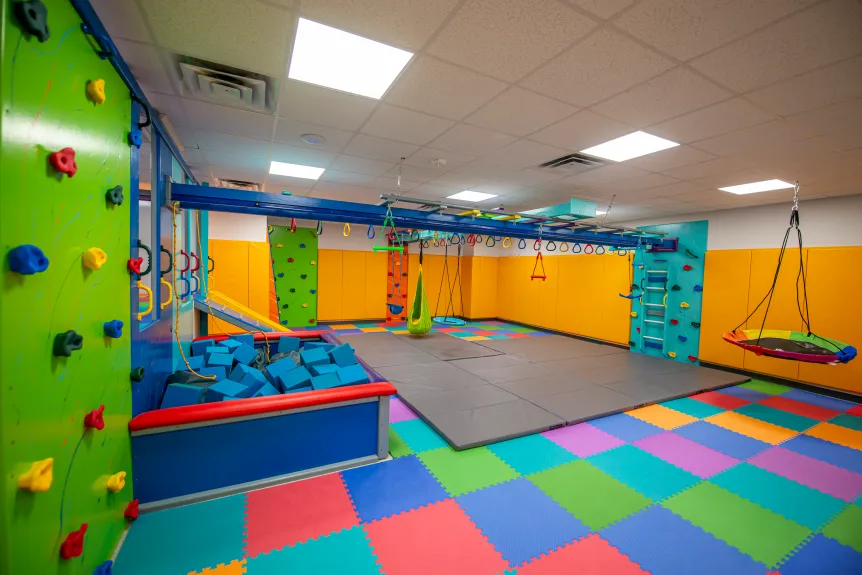 An interior image of the Families of Autistic Children in Tidewater (FACT) building that showcases the gym and play equipment for visitors and participants in FACT programs.