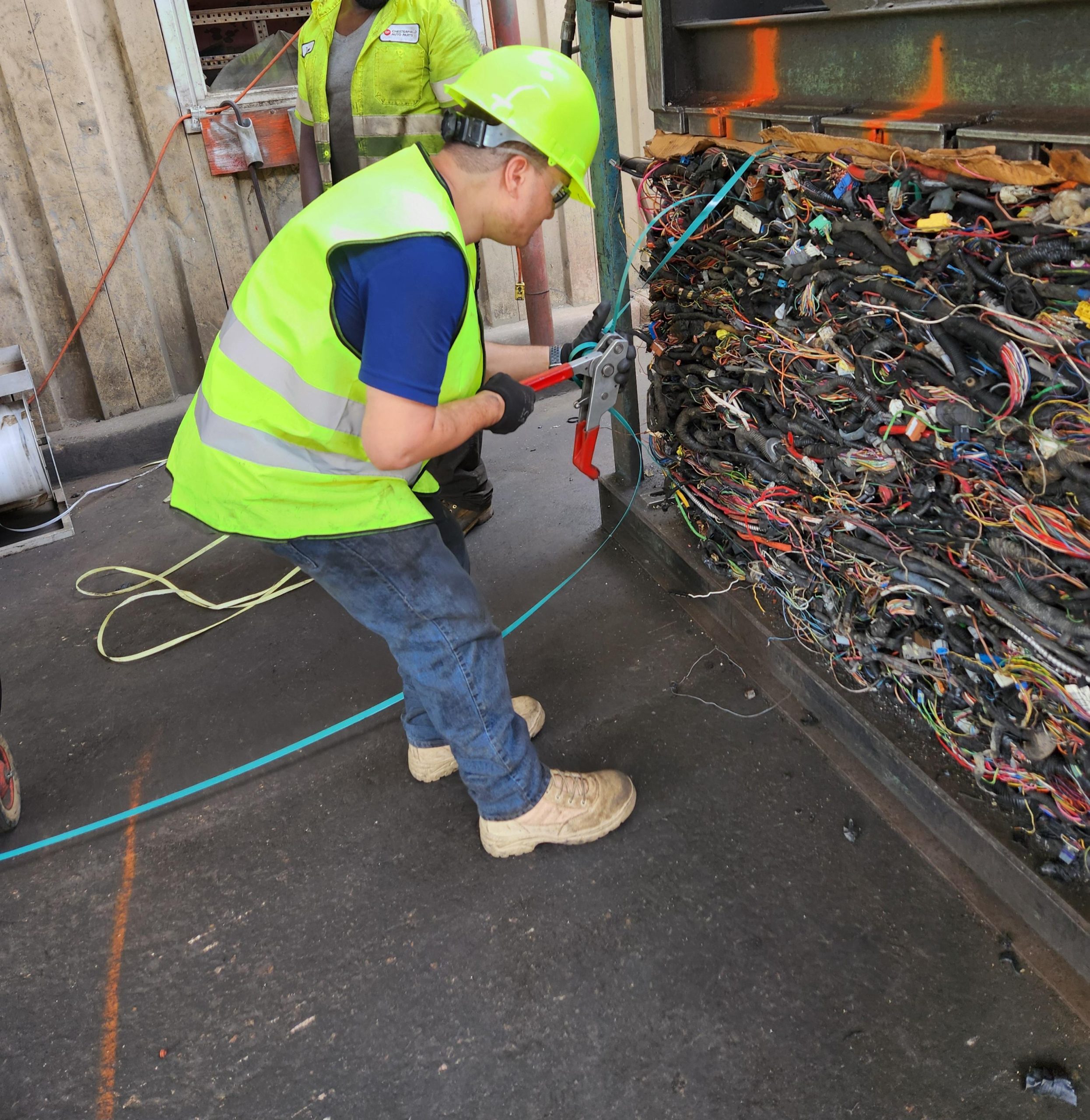 Intern, Luan, from Career Readiness and Employment wearing hard hat and vest while working at Chesterfield Auto Parts